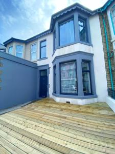 a large house with a wooden deck in front of it at Kensington Suite Sasco Apartments in Blackpool