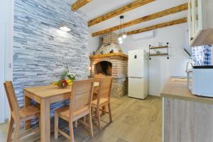eine Küche und ein Esszimmer mit einem Tisch und einem Kamin in der Unterkunft Apartments Crno in Zadar