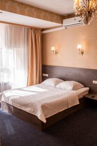 Un dormitorio con una cama grande y una ventana en Malibu Hotel, en Omsk