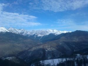 uma vista para uma serra com montanhas cobertas de neve em Gornaya Rezidentsiya Aparthotel em Estosadok