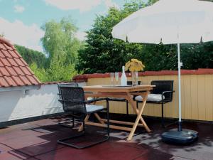 een tafel en stoelen onder een parasol op een patio bij Ferienwohnung auf der Baar in Bad Dürrheim