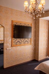 Malibu Hotel في أومسك: غرفة معيشة فيها تلفزيون على جدار