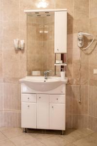 y baño con lavabo blanco y espejo. en Malibu Hotel, en Omsk