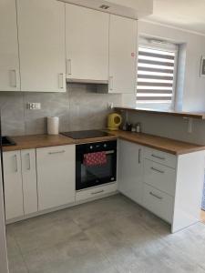 una cucina con mobili bianchi e un forno a piano cottura di Apartament al. Solidarności a Białystok