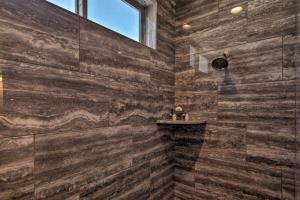 a bathroom with a large shower with wooden walls at Luxe Home with OHV Access, 5 Mi to Lake Mohave! in Bullhead City