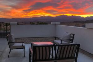 a patio with chairs and a table with a sunset at Luxe Home with OHV Access, 5 Mi to Lake Mohave! in Bullhead City