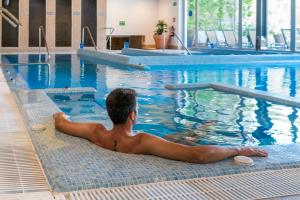 a man laying in a swimming pool at ARTIEM Audax - Adults Only in Cala Galdana