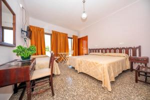 een slaapkamer met twee bedden, een bureau en ramen bij Hostal Santa Eulalia in Santa Eularia des Riu