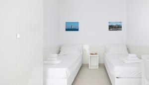 - 2 lits dans une chambre aux murs blancs dans l'établissement Rivazzurra Homes - B, à Termoli