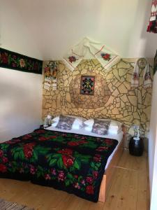 um quarto com uma cama com uma parede de pedra em Casa Cezara em Silvaşu de Jos