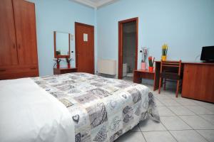 Schlafzimmer mit einem Bett, einem Schreibtisch und einem TV in der Unterkunft Hotel Gentile in Agerola