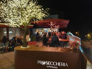 people sitting at a table with umbrellas at B&B La Montanara in San Martino di Castrozza