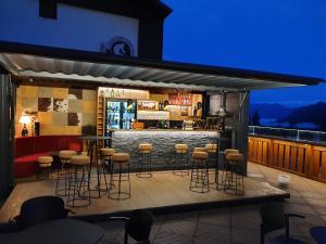 un bar en la azotea de un edificio con taburetes en B&B La Montanara en San Martino di Castrozza