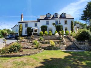 a large white house with a landscaped yard at The Mount Pleasant Hotel in Sidmouth