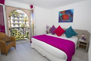 a bedroom with a large bed and a balcony at Cristal Hôtel & Spa in Cannes
