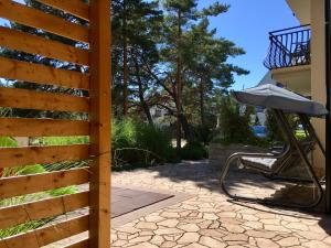 a fence with a chair and an umbrella on a patio at Apartamenty Czarny Kormoran in Hel