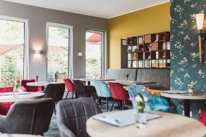 a restaurant with tables and chairs and windows at Hotel Hildebrandt's in Neumünster