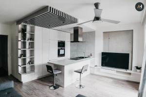 a kitchen with white cabinets and a large tv at AH Radnica III in Košice