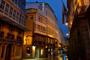 une rue de la ville avec des bâtiments la nuit dans l'établissement Hotel Alda Galería Coruña, à La Corogne