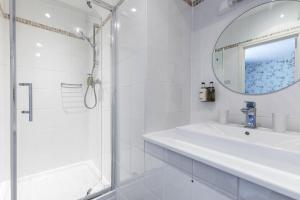 a white bathroom with a sink and a shower at The Mount Pleasant Hotel in Sidmouth
