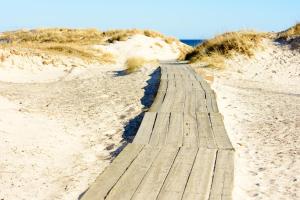 un sentiero in legno attraverso la sabbia su una spiaggia di Österlencharm a Löderup