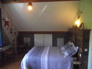 1 dormitorio con cama y pared de ladrillo en chambres du grès rouge de Beauval, en Beauval