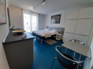 a bedroom with a bed and a desk with a chair at Domus Hotel in Luxembourg