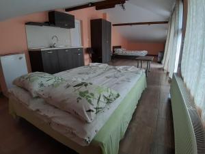 1 Schlafzimmer mit einem großen Bett und einer Küche in der Unterkunft Къща за гости Романс in Yagodina