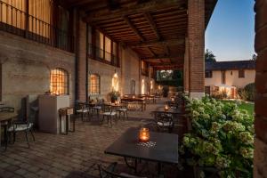 an outdoor patio with tables and chairs and plants at Santellone Resort in Brescia