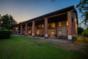 un gran edificio de ladrillo con mesas y sillas en Santellone Resort en Brescia