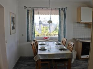 uma mesa de jantar com cadeiras e uma janela em Ferienwohnung Arnold Laubbach em Ostrach