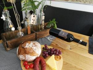 una mesa de madera con una botella de vino y un plato de comida en Ferienwohnung Gugel, en Kandern