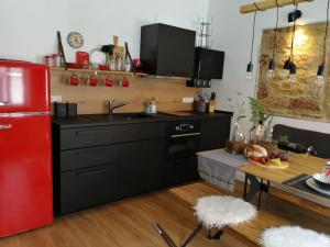 cocina con armarios negros y nevera roja en Ferienwohnung Gugel, en Kandern