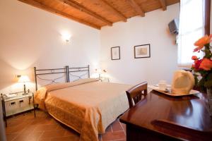 a bedroom with a bed and a desk and a table at Agriturismo Santa Maria Bressanoro in Castelleone