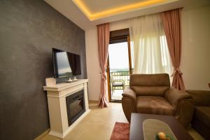 sala de estar con sofá, TV y chimenea en Zlatibor Hills Afrodita & Spa en Zlatibor