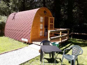 uma pequena casa com uma mesa e cadeiras em frente em La Pointe Camping em Châteaulin