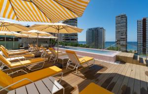 a patio with chairs and umbrellas and a swimming pool at The Agir Springs Hotel by Medplaya in Benidorm