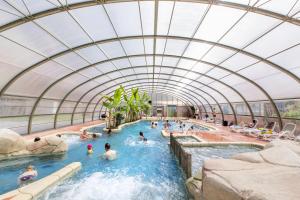 a group of people swimming in an indoor swimming pool at See Breizh by Home From Home in Saint Malo