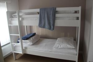 a white bunk bed with a blue towel on it at Huis Ter Duin in Koksijde