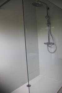 a glass shower with a shower head in a bathroom at Huis Ter Duin in Koksijde +3 photos
