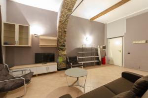 un soggiorno con divano e tavolo di JOIVY Warm Family Flat for 9, near Porto Antico a Genova