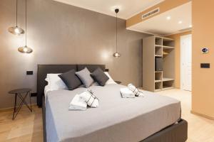 a bedroom with a large bed with two pillows at Teseo Rooms & Relax in Genova