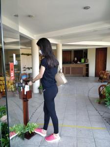 a woman is standing at a parking meter at Divi-Divi Praia Hotel in Natal