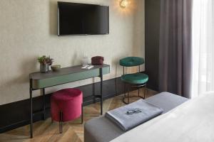 a hotel room with a bed and a table and stools at Hotel Forte del 48 in San Donà di Piave