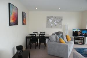 sala de estar con sofá y mesa de comedor en Coastal City Rooms - Waterfront, en Swansea