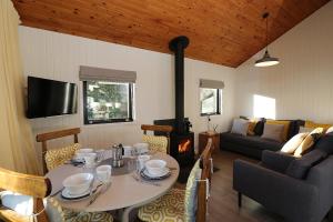 a living room with a table and a couch at Cosy Modern Nordic Lodge w/ Loch View & Log Burner in Lochearnhead