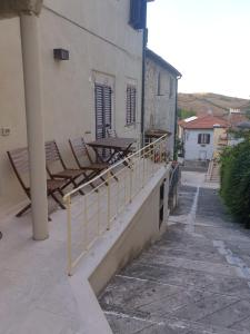 a balcony with chairs and tables on a building at Bagni San Filippo Casa gelsomino in Bagni San Filippo