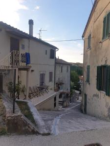 un callejón en una casa antigua con balcón en Bagni San Filippo Casa gelsomino en Bagni San Filippo
