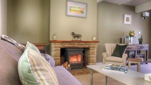 a living room with a fireplace with a horse statue on the wall at Ivy Cottage in Bourton on the Water
