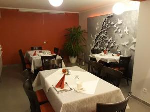 a dining room with two tables with white table cloth at Culina in Oberlungwitz